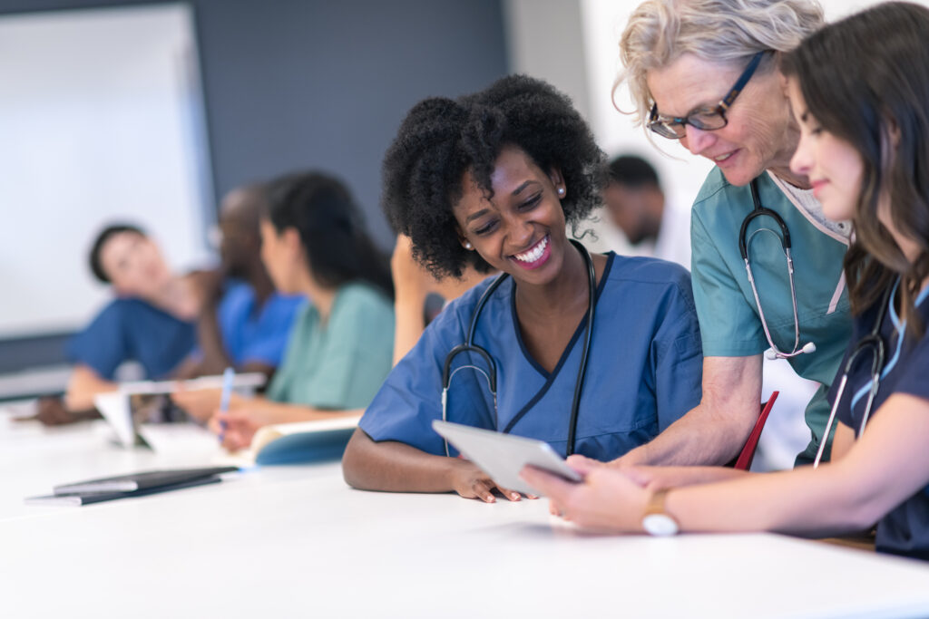 Senior female lecturer assists medical students during class